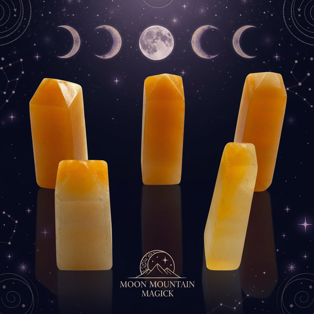 Five faceted orange-yellow crystal points or tumbled stone pieces arranged on a plain white surface.